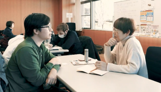 日本語教室で講師と生徒が話す様子